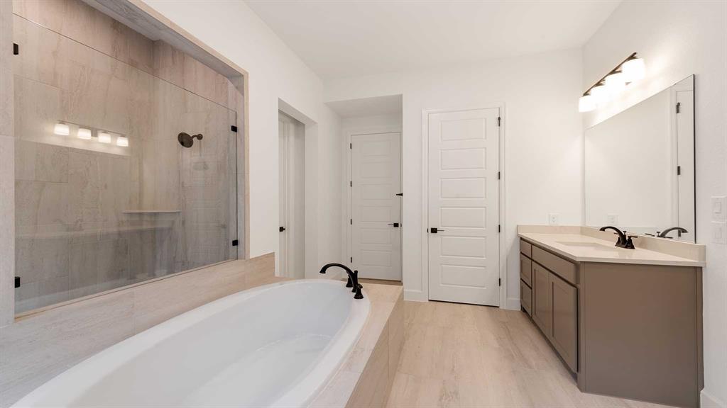 829 Stoney Bridge Way Lavon, TX 75166 - Photo 16 of 35 a spacious bathroom with a tub sink and mirror