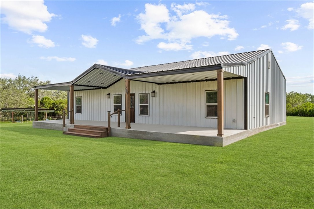 207 South Charles Street George West, TX 78022 - Photo 4 of 24 a front view of a house with a garden and yard
