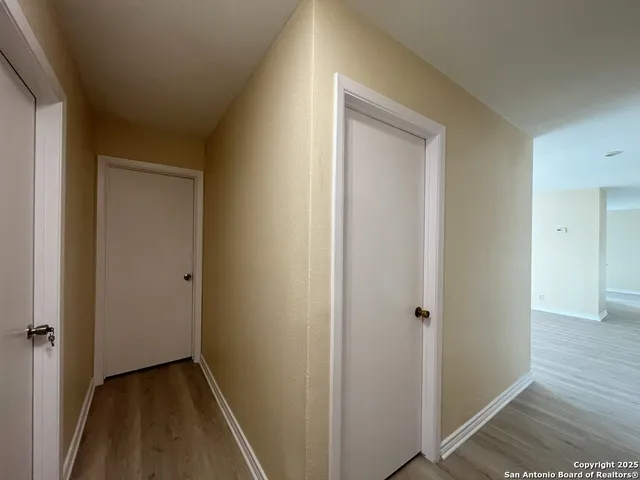 a view of hallway with closet and wooden floor