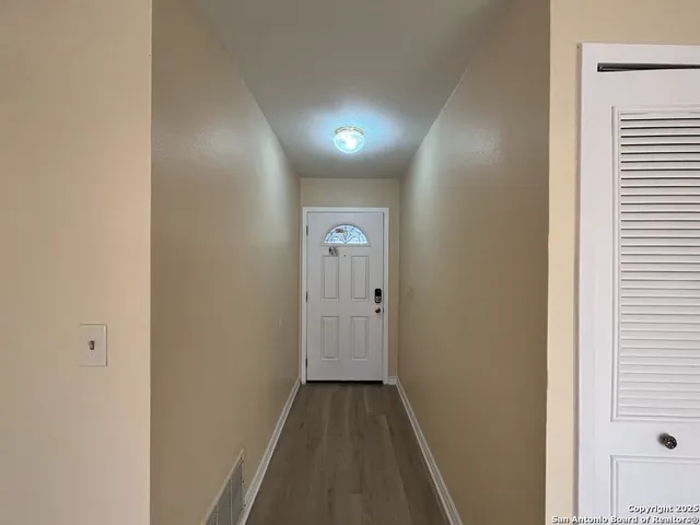 a view of hallway with wooden floor