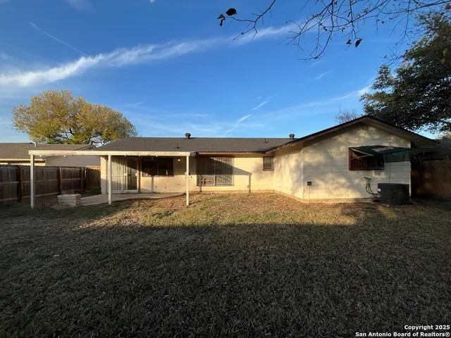 a view of house with backyard and glass windows