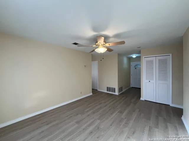 a view of an empty room with wooden floor