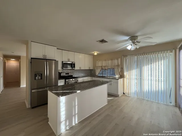 a kitchen with kitchen island a sink appliances and cabinets
