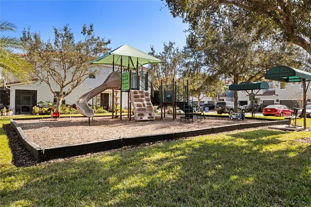 a view of swimming pool with outdoor seating and trees in the background