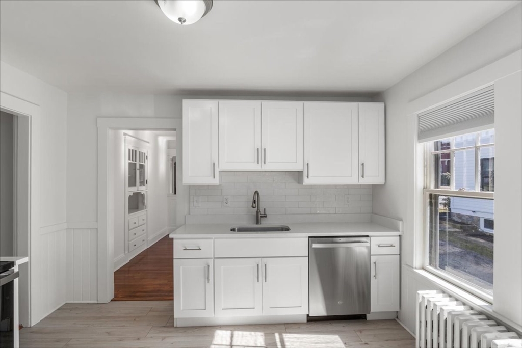 558 Lagrange Street, Unit 1 Boston, MA 02132 - Photo 11 of 40 a kitchen with stainless steel appliances granite countertop a sink and a stove top oven