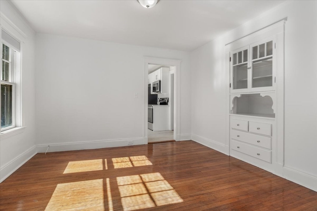 558 Lagrange Street, Unit 1 Boston, MA 02132 - Photo 20 of 40 a big room with wooden floor and windows