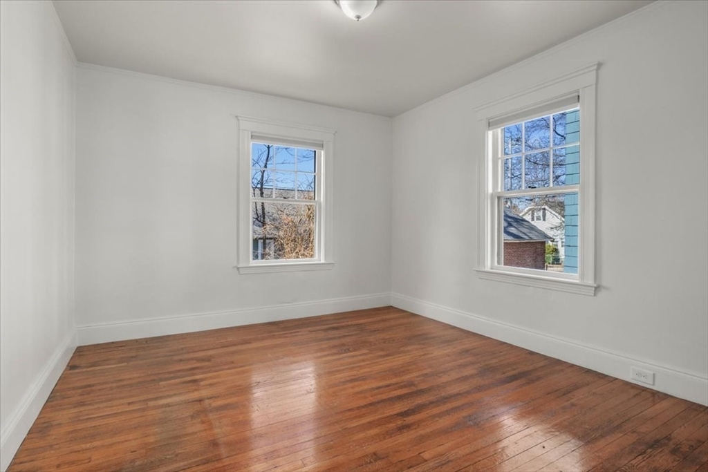 558 Lagrange Street, Unit 1 Boston, MA 02132 - Photo 28 of 40 a view of an empty room with window and wooden floor