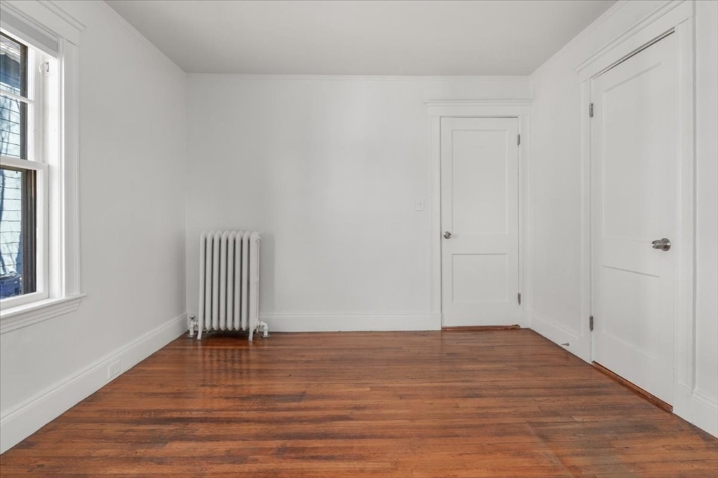 558 Lagrange Street, Unit 1 Boston, MA 02132 - Photo 32 of 40 a view of empty room with wooden floor and fan