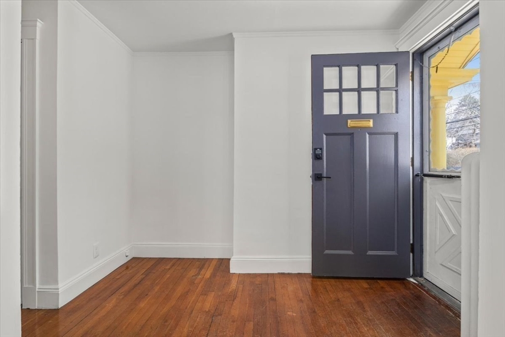 558 Lagrange Street, Unit 1 Boston, MA 02132 - Photo 36 of 40 an empty room with wooden floor and a window
