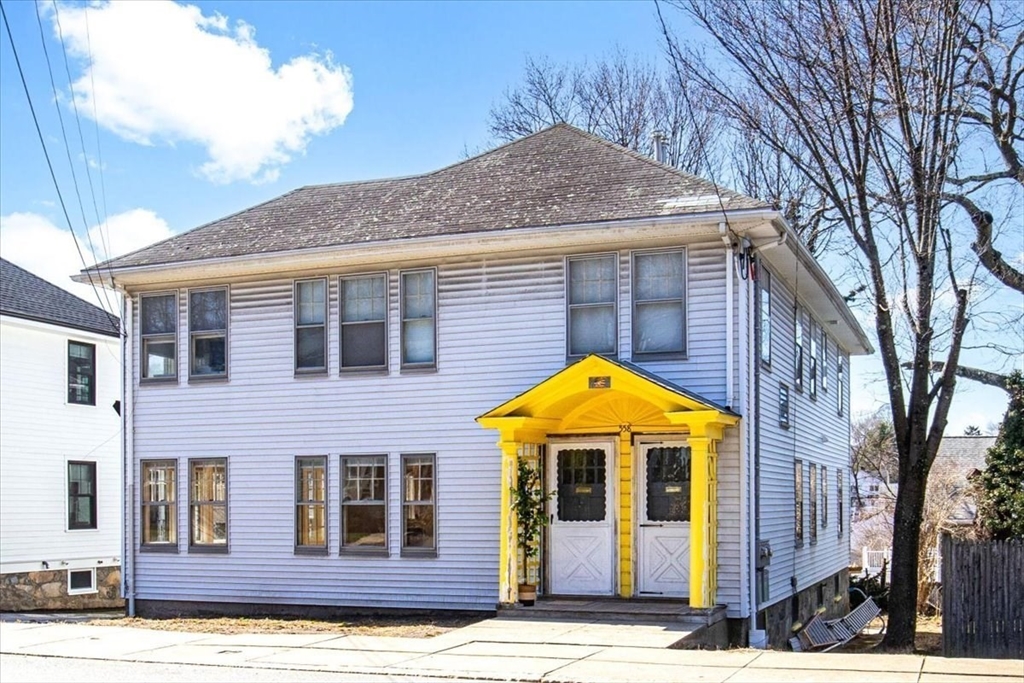 558 Lagrange Street, Unit 1 Boston, MA 02132 - Photo 39 of 40 a view of a white house with large windows and a small yard