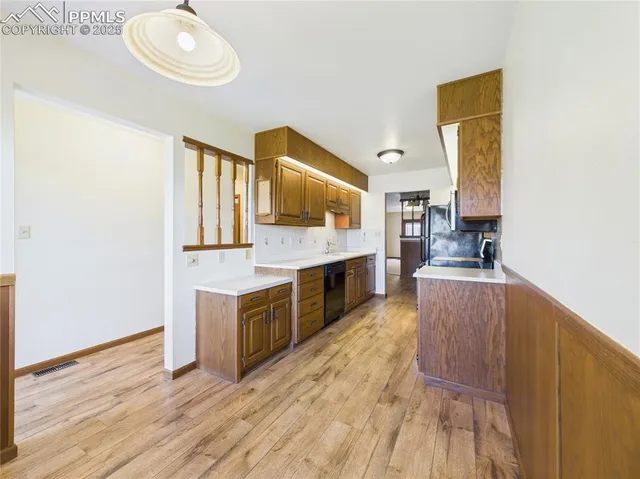 a large kitchen with kitchen island granite countertop wooden floors and a sink