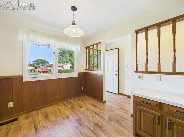 a view of a room with wooden floor and a window