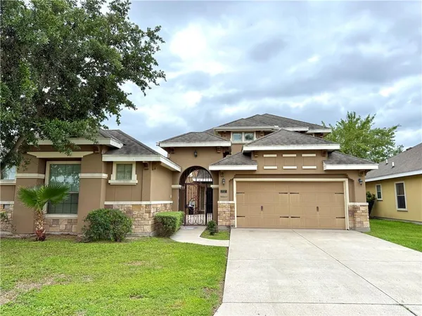 a front view of a house with a garden and garage