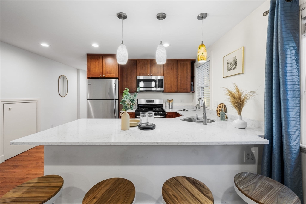50 Spring Street Cambridge, MA 02141 - Photo 12 of 36 a kitchen with stainless steel appliances kitchen island granite countertop a sink a refrigerator and a granite counter tops