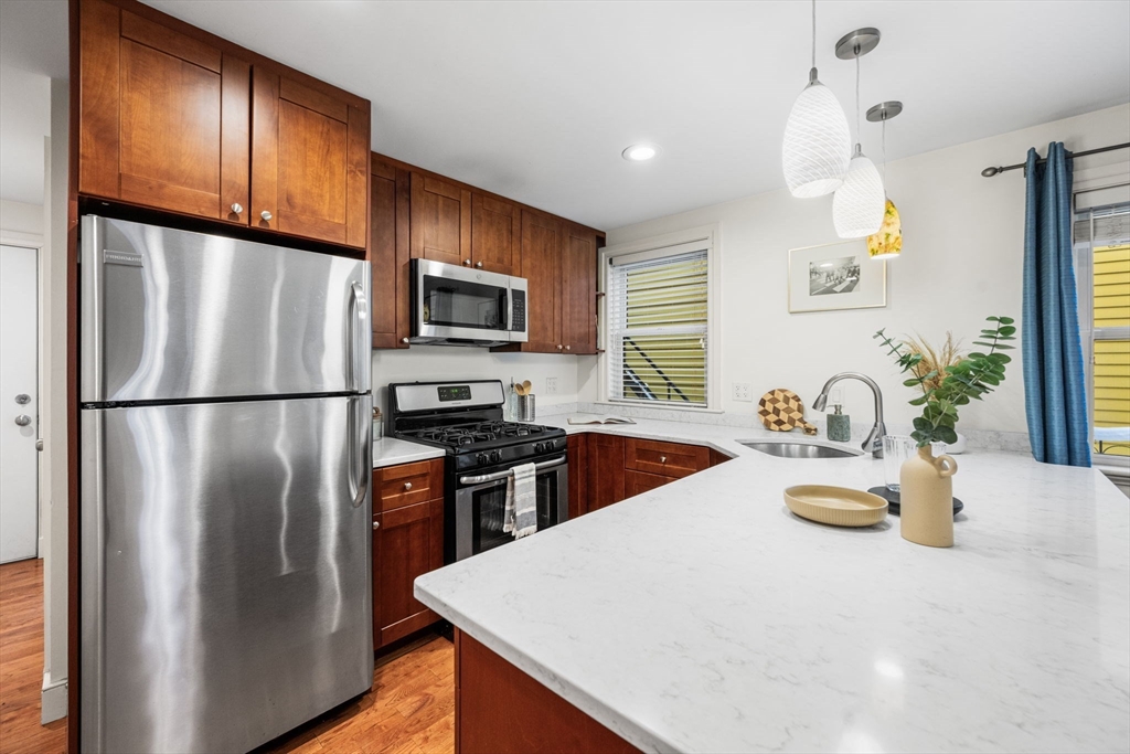 50 Spring Street Cambridge, MA 02141 - Photo 14 of 36 a kitchen with stainless steel appliances granite countertop a refrigerator a stove a sink dishwasher a refrigerator with wooden floor