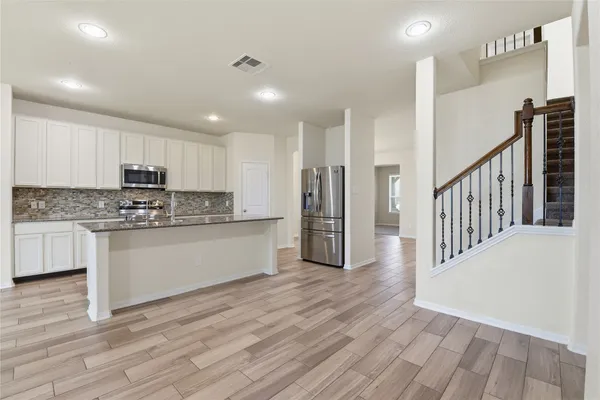 a kitchen with stainless steel appliances granite countertop a stove a sink and a refrigerator