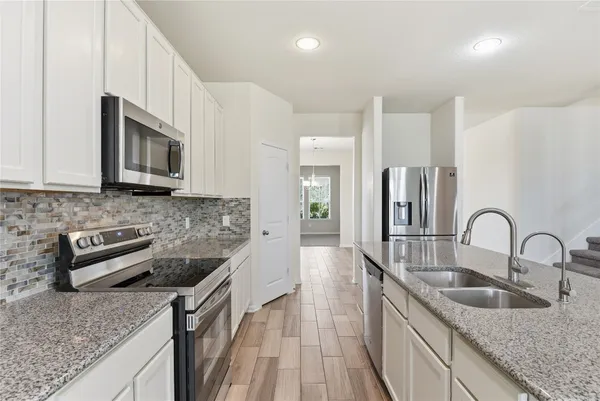 a kitchen with granite countertop a sink and stainless steel appliances