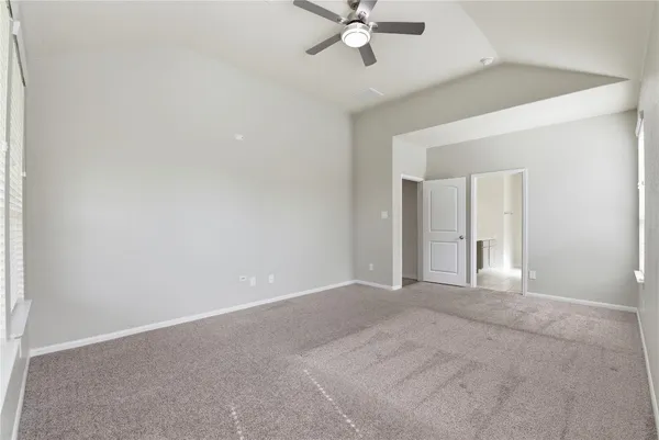 a view of an empty room with a chandelier fan