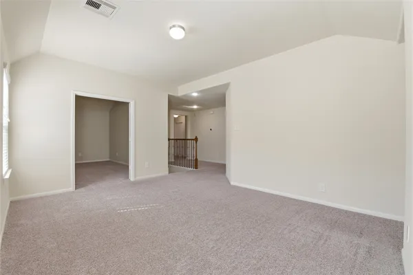 a view of an empty room and a kitchen