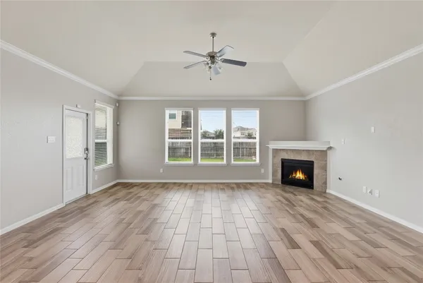 wooden floor fireplace and windows in an empty room