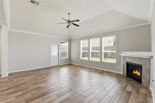 a view of empty room with wooden floor and fireplace