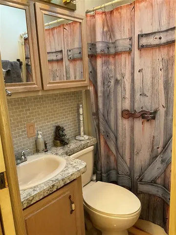 a bathroom with a toilet and a shower