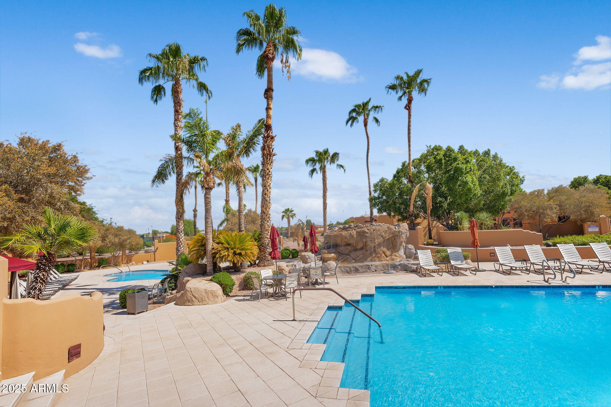 8865 East Baseline Road, Unit 802 Mesa, AZ 85209 - Photo 36 of 44 a view of a swimming pool with a table and chairs