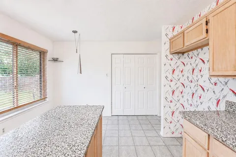 a view of kitchen with granite countertop cabinets and sink