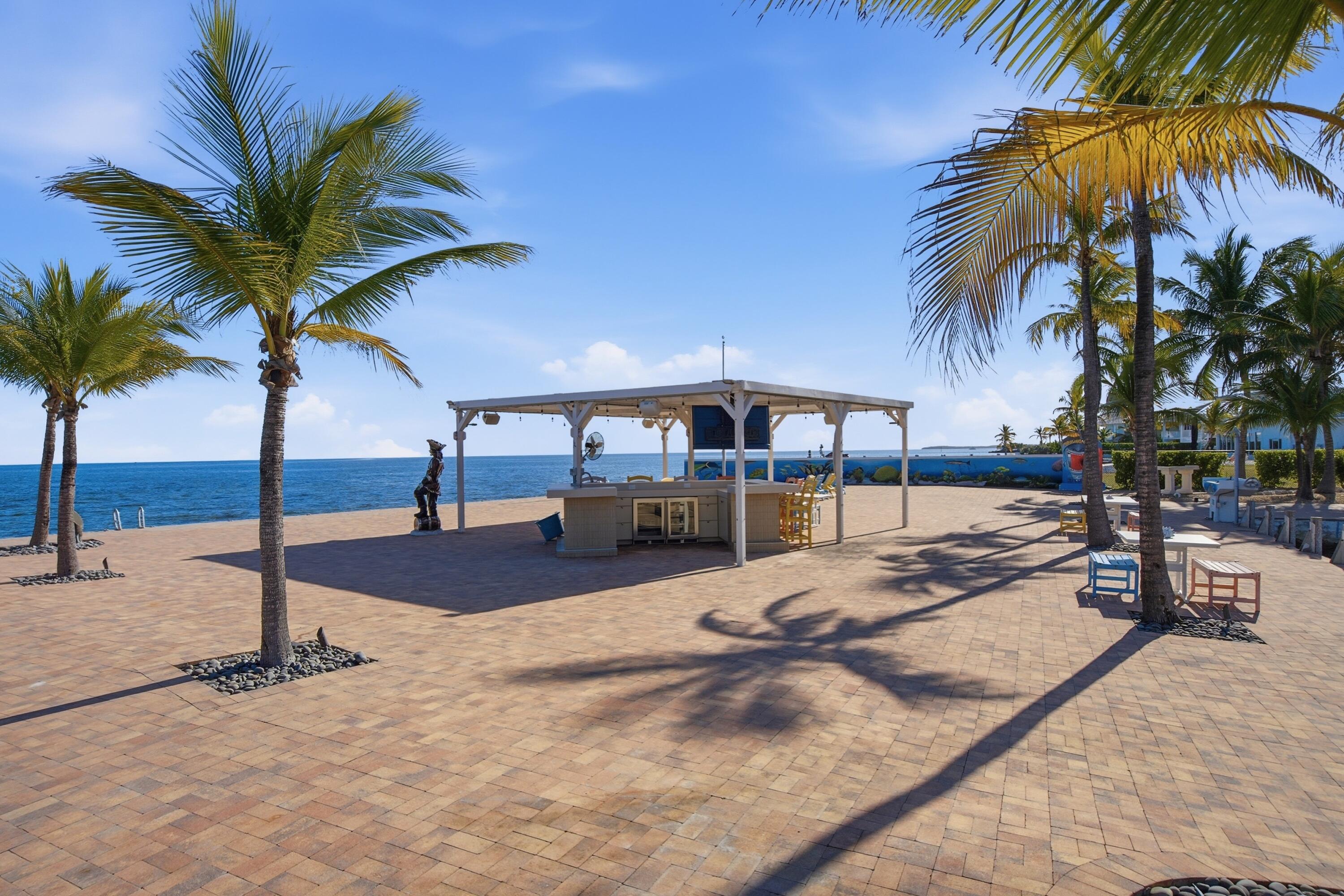 101 Oleander Circle Key Largo, FL 33037 - Photo 102 of 126 a view of a swimming pool with a lounge chair and palm trees