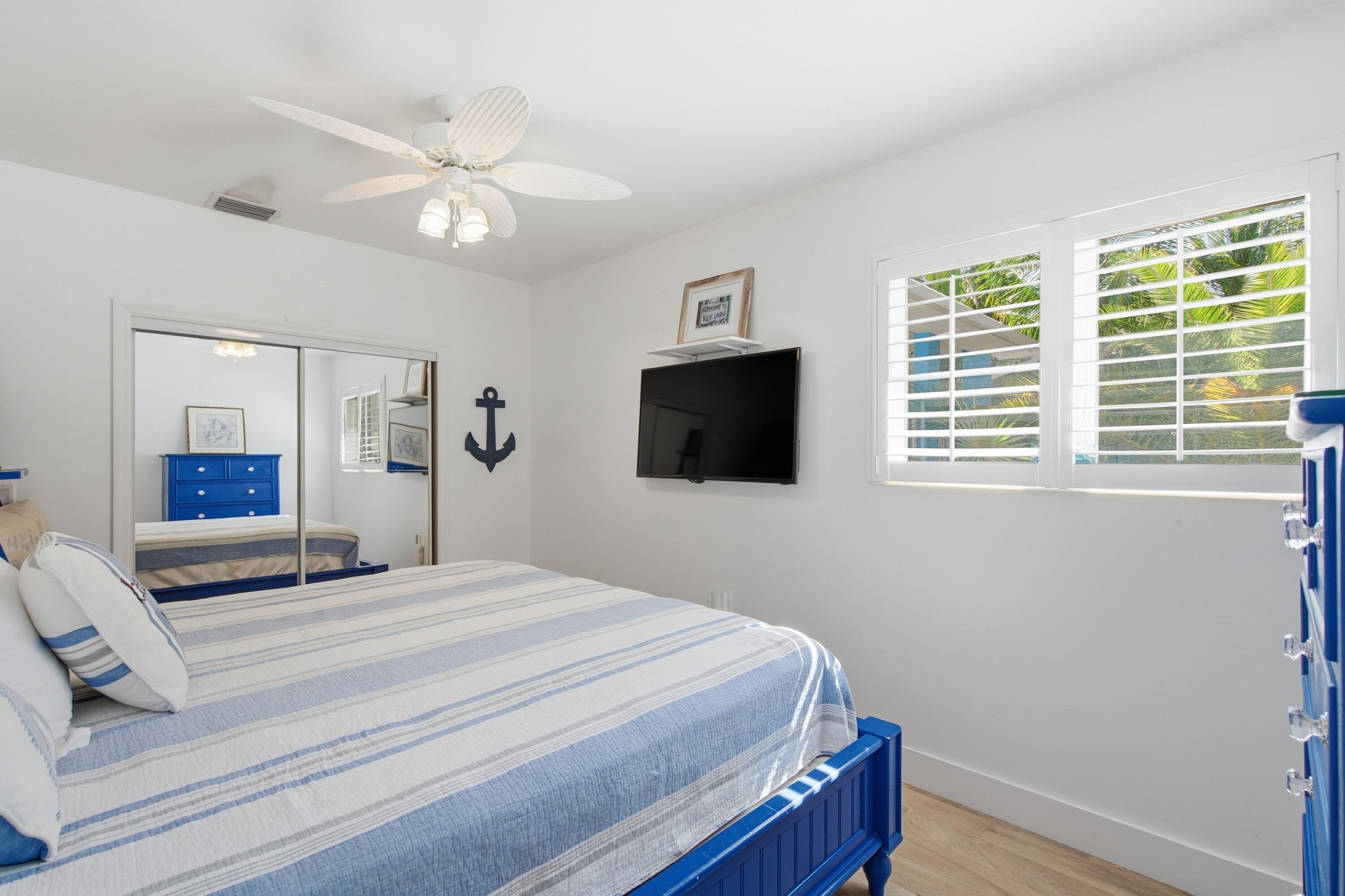 101 Oleander Circle Key Largo, FL 33037 - Photo 43 of 126 a bedroom with a large bed a flat tv screen and dresser