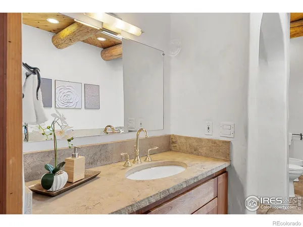 a bathroom with a granite countertop sink a mirror and vanity