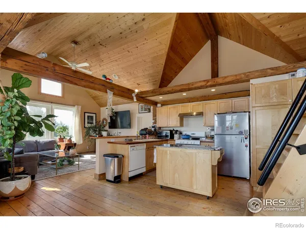a kitchen with stainless steel appliances kitchen island granite countertop a refrigerator a stove a sink and dishwasher