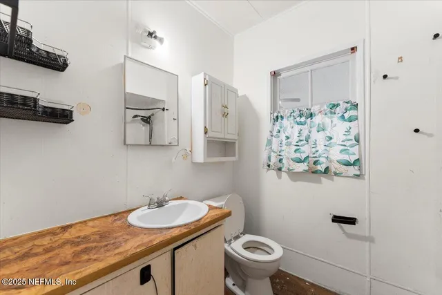 a bathroom with a granite countertop sink and a toilet