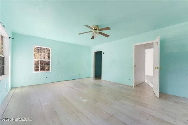 an empty room with fan and windows
