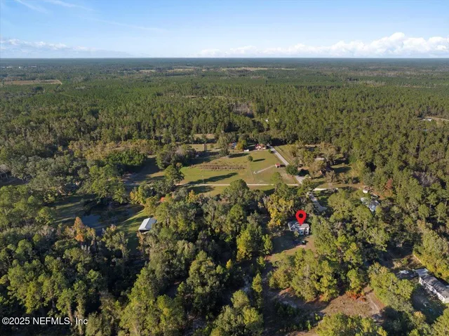 an aerial view of residential house with outdoor space and trees