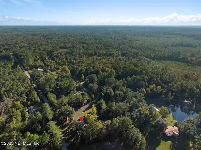 an aerial view of residential houses with outdoor space and trees