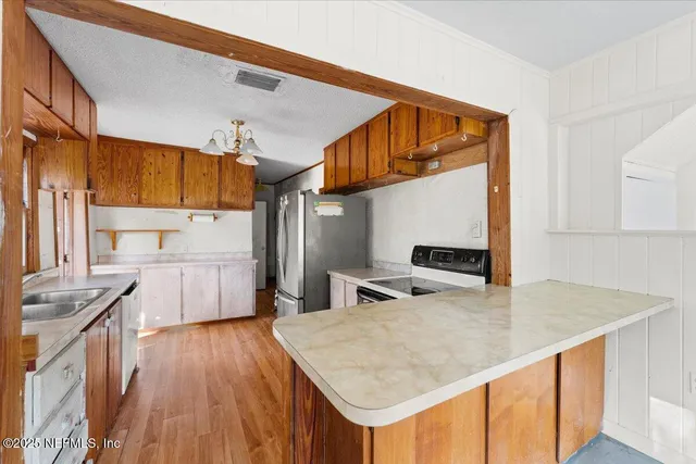 a kitchen with stainless steel appliances granite countertop a sink refrigerator and microwave