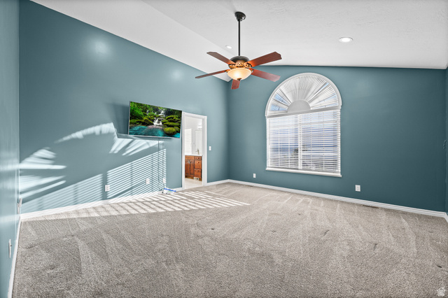 4117 North Wolf Ridge Circle Eden, UT 84310 - Photo 18 of 63 Spacious room featuring vaulted ceilings, a ceiling fan with integrated lighting, recessed lighting, an arched window with blinds, and neutral-toned carpeting