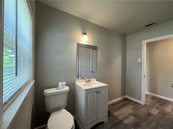 a bathroom with a sink toilet and window