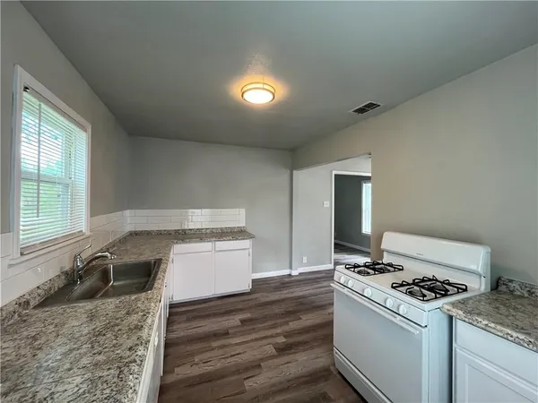 a kitchen with a stove and a granite counter tops