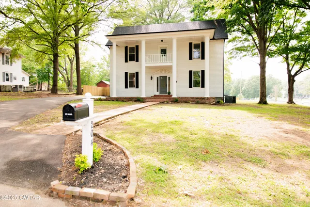 a view of a house with pool and sitting area