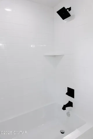 an empty room with wooden floor cabinet and windows