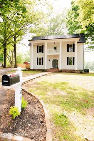 a front view of a house with a road