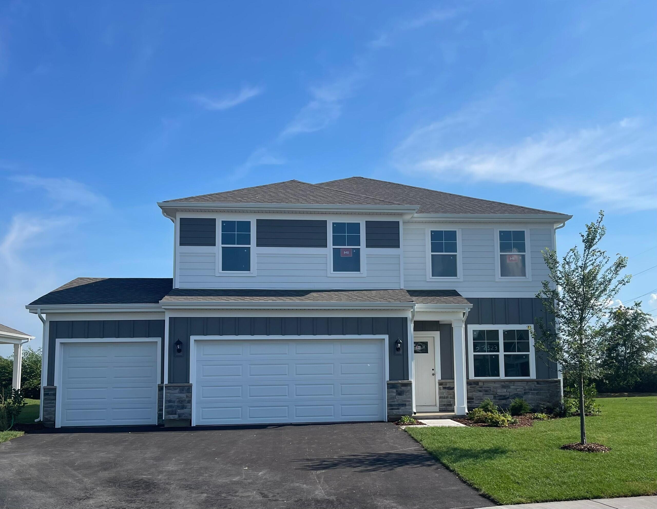 a front view of a house with a garden and yard