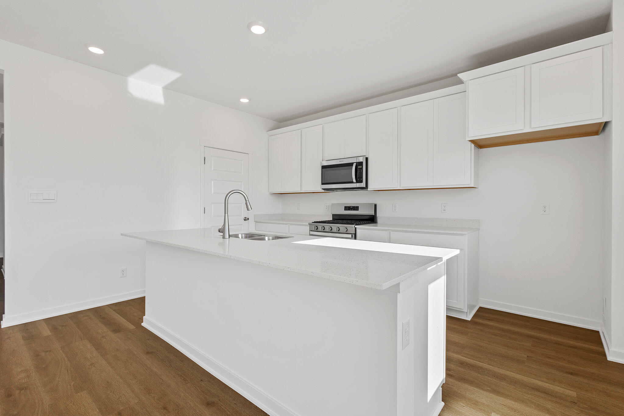 7347 West 107th Place Crown Point, IN 46307 - Photo 5 of 26 a kitchen with a sink a stove a microwave and cabinets