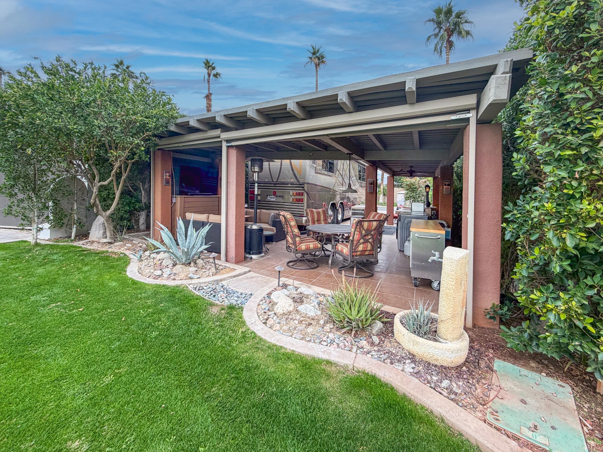 80394 Ave 48, Unit 281 Indio, CA 92201 - Photo 9 of 15 a view of a patio with table and chairs potted plants and large tree