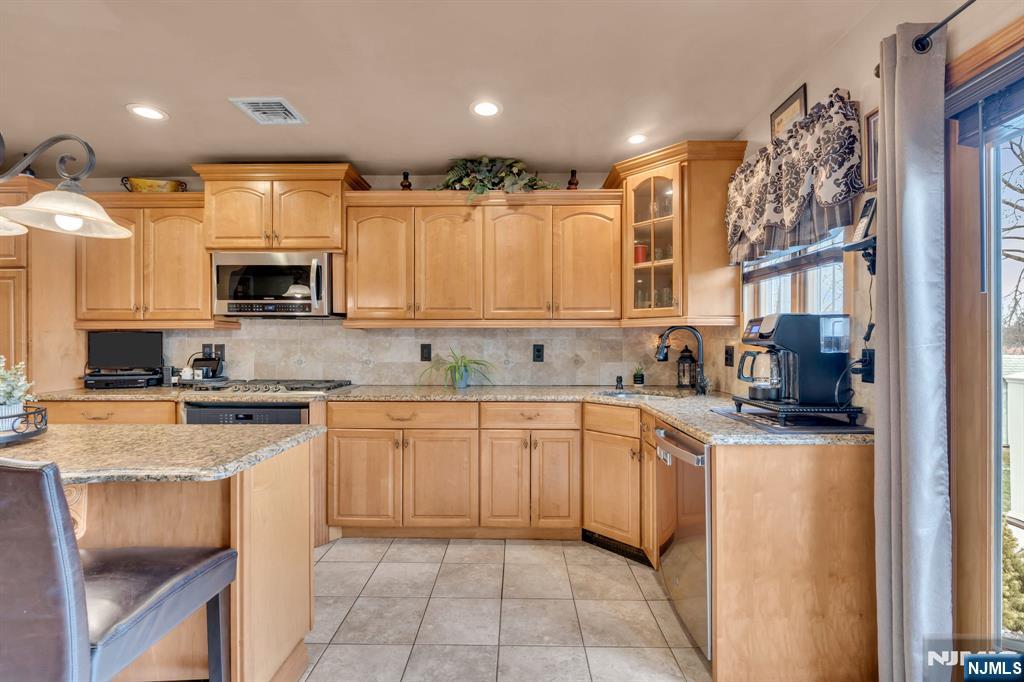 104 Prospect Street Nutley, NJ 07110 - Photo 12 of 41 a kitchen with stainless steel appliances granite countertop a stove top oven a sink dishwasher and a refrigerator
