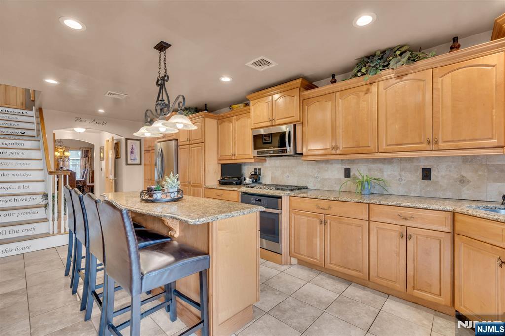 104 Prospect Street Nutley, NJ 07110 - Photo 14 of 41 a kitchen with stainless steel appliances kitchen island granite countertop a sink and cabinets