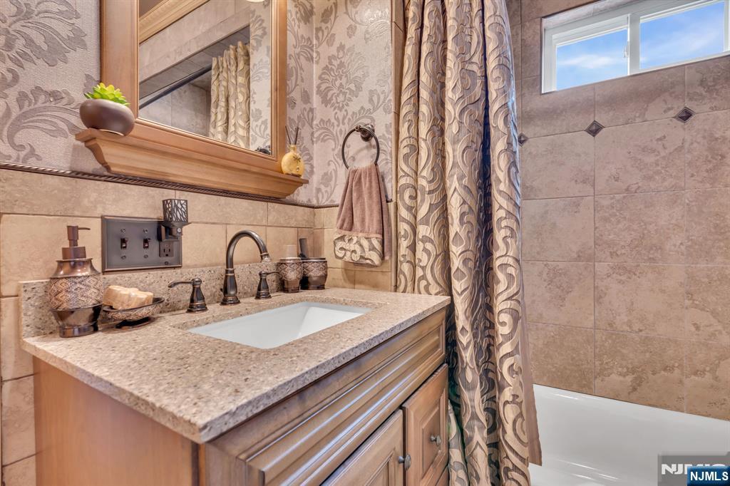 104 Prospect Street Nutley, NJ 07110 - Photo 24 of 41 a bathroom with a granite countertop sink a mirror and shower
