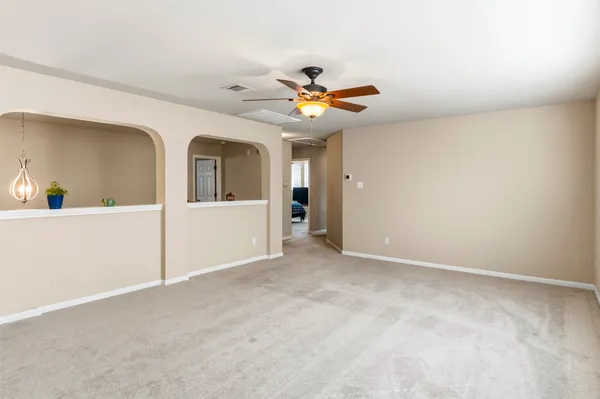an empty room with windows and fan